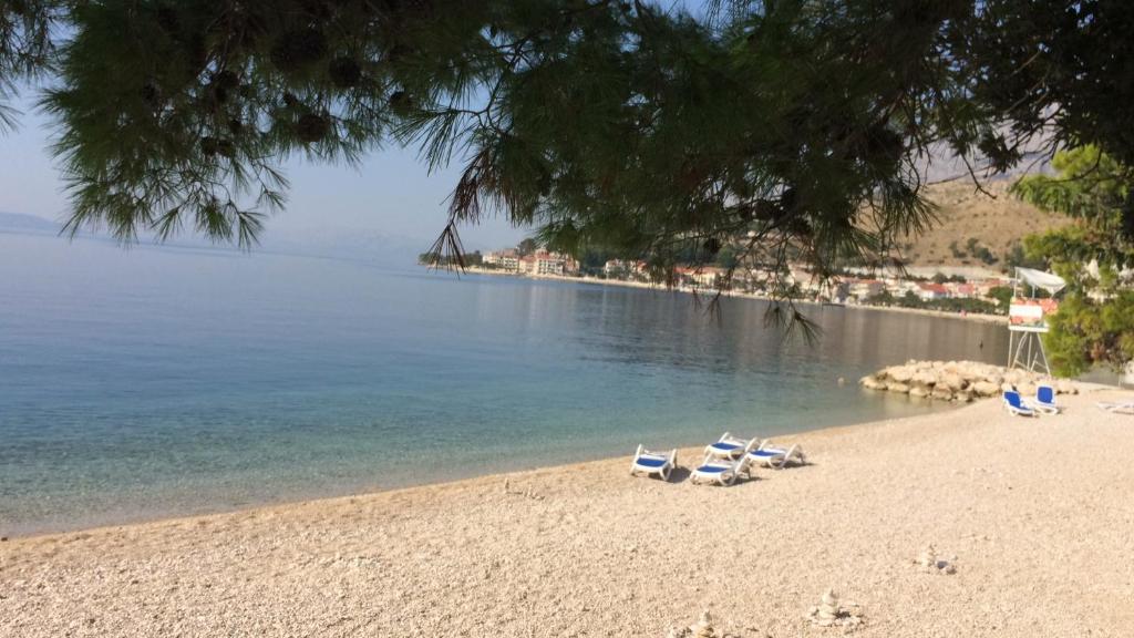 a beach with lounge chairs and the water at Apartment Kastel in Podgora