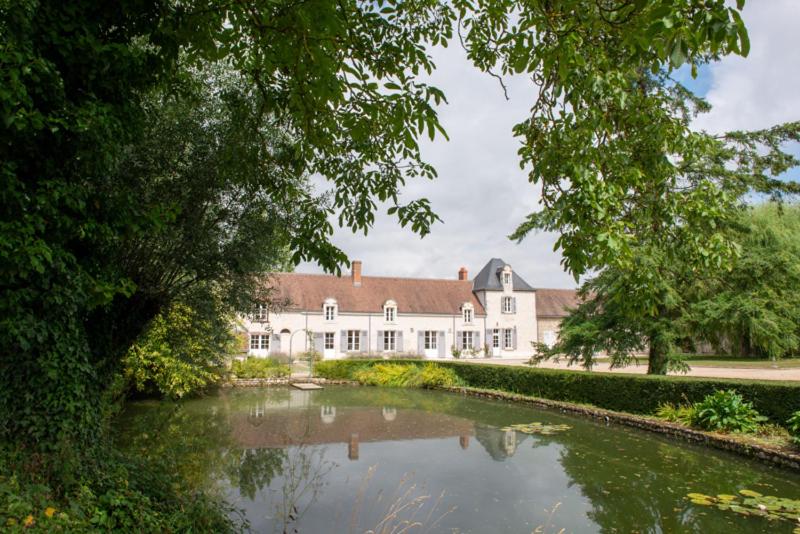 Lailly-en-ValにあるMANOIR DE BOURGNEUFの池を前に広い白い家