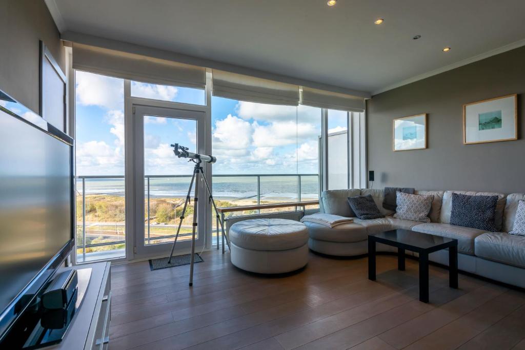 ein Wohnzimmer mit Meerblick in der Unterkunft Panoramic & Modern apartment with sea view in Bredene