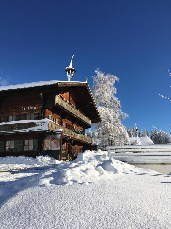 un bâtiment dans la neige avec un sapin de Noël dans l'établissement Bergpension Zinting, à Brixen im Thale