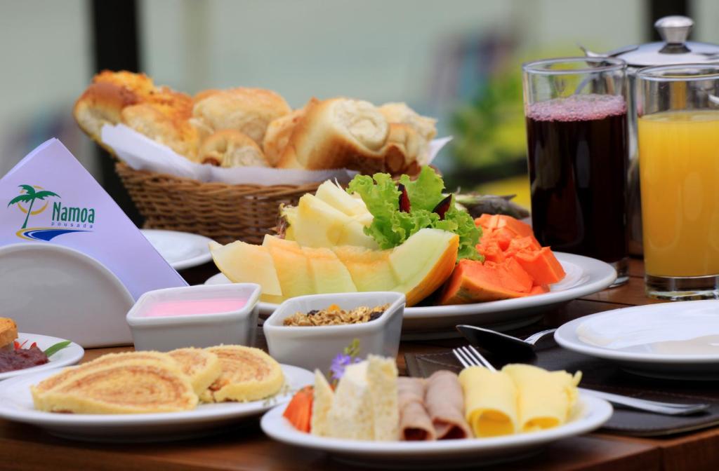 - une table avec des assiettes de nourriture et de boissons dans l'établissement Namoa Pousada, à Cabo de Santo Agostinho