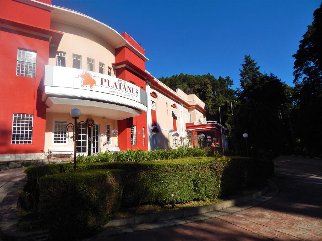 a red and white building with a sign for a pharmacy at Hotel Platanus in Campos do Jordão