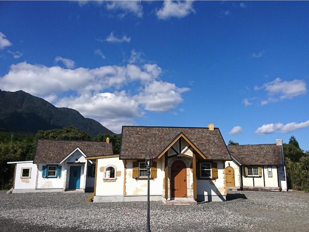 ein weißes Haus mit einer Auffahrt davor in der Unterkunft Cottage Morinokokage in Yakushima