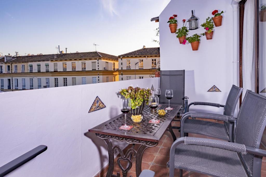 einen Tisch auf dem Balkon mit Gläsern Wein in der Unterkunft Junto a la casa natal de Picasso in Málaga