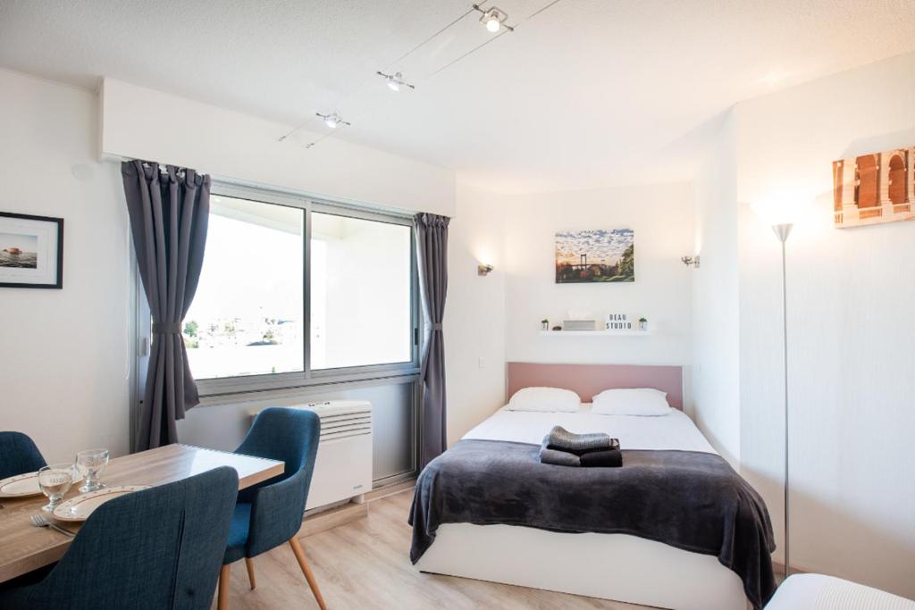 een slaapkamer met een bed, een bureau en een raam bij Escapade Bordeaux, tram et supermarché au pied in Mérignac