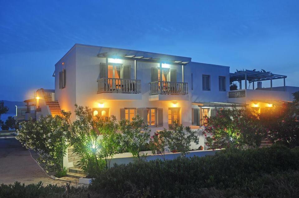 a white house with lights on at night at Hotel Rigas in Adamas