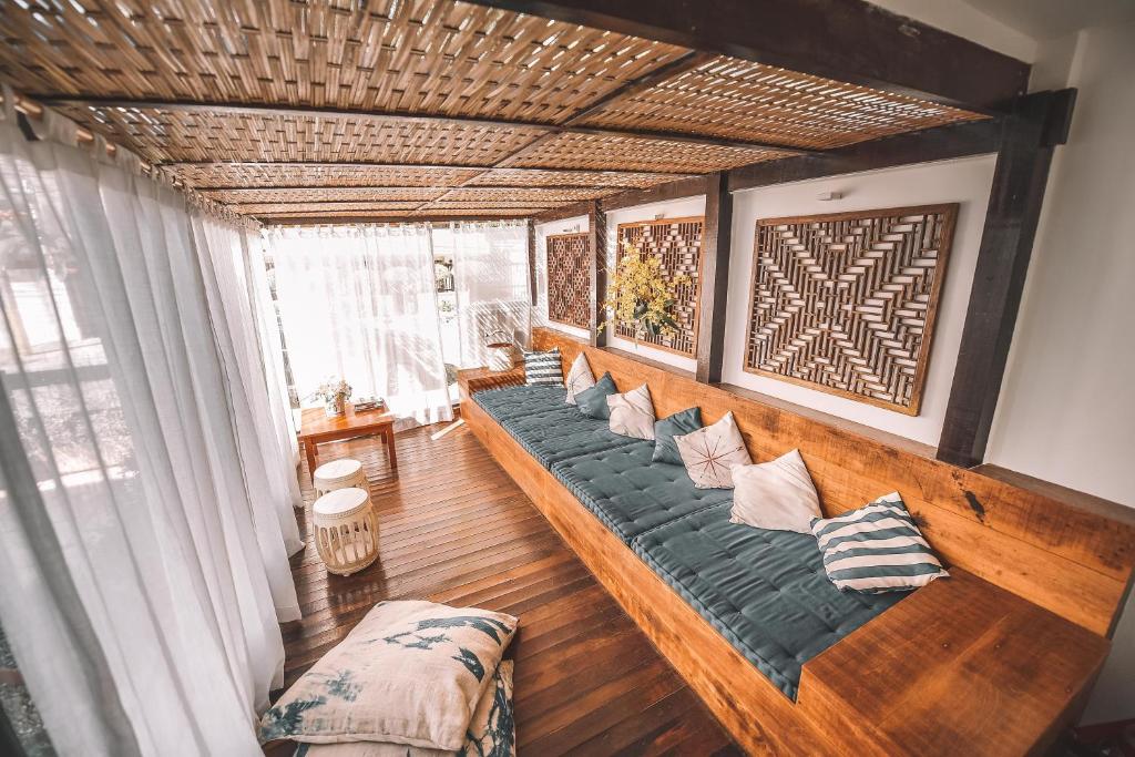 a living room with a long couch with pillows at Pousada da Prainha in Arraial do Cabo