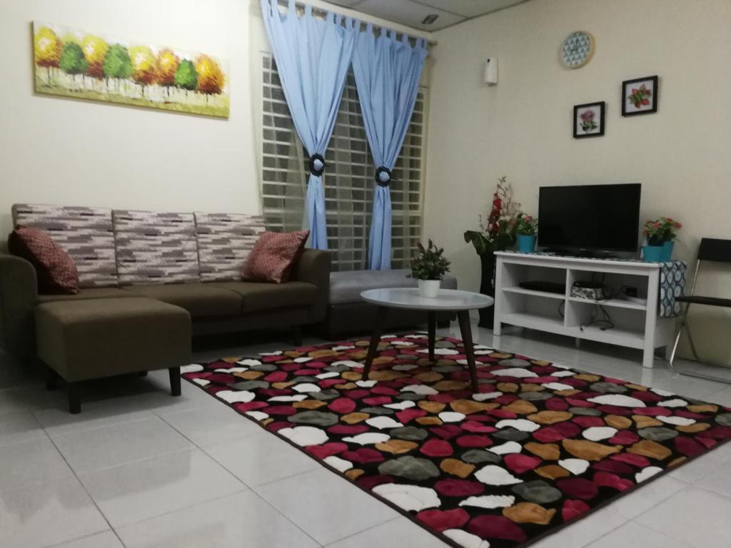 un soggiorno con divano e tavolo di A1-04-03 Damiana Apartment a Tanjung Malim