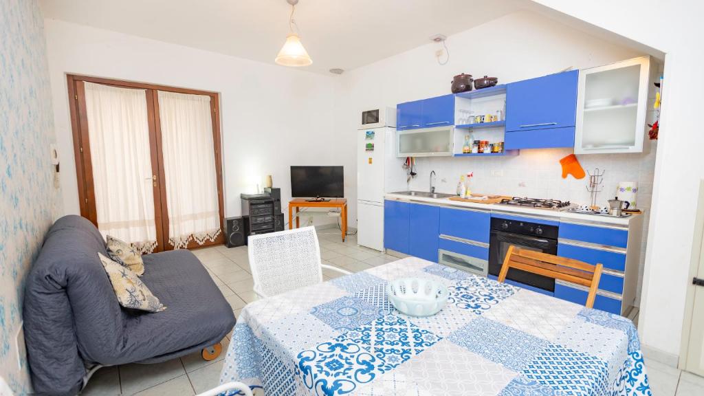 a living room with a table and a kitchen at Casa Lua in Villasimius