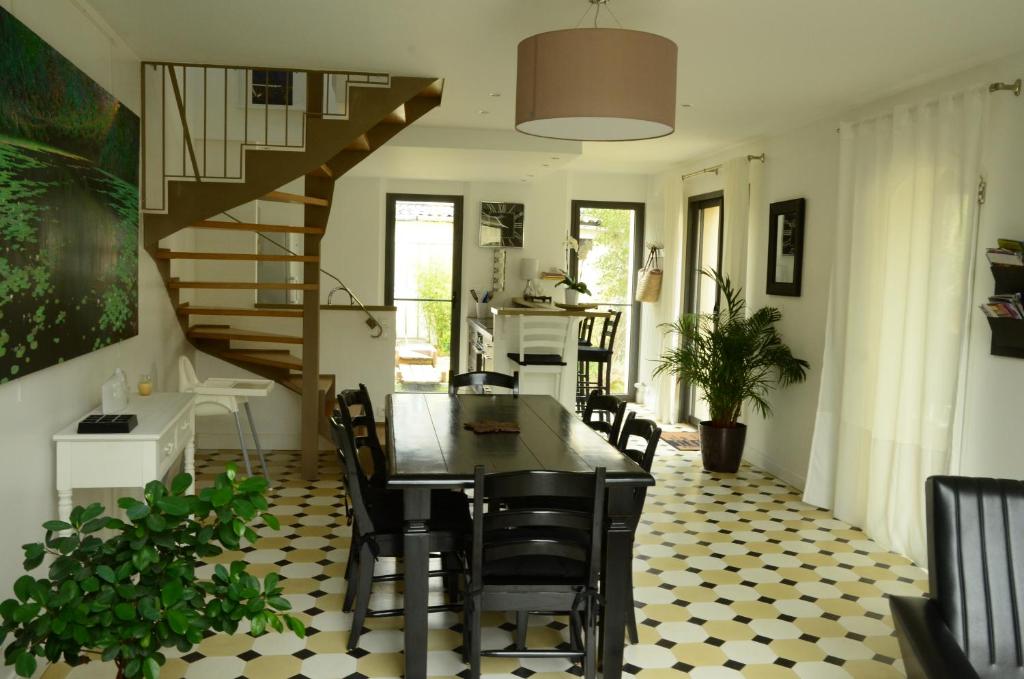 a dining room with a table and chairs and a staircase at Le petit Valhalla in Bayeux