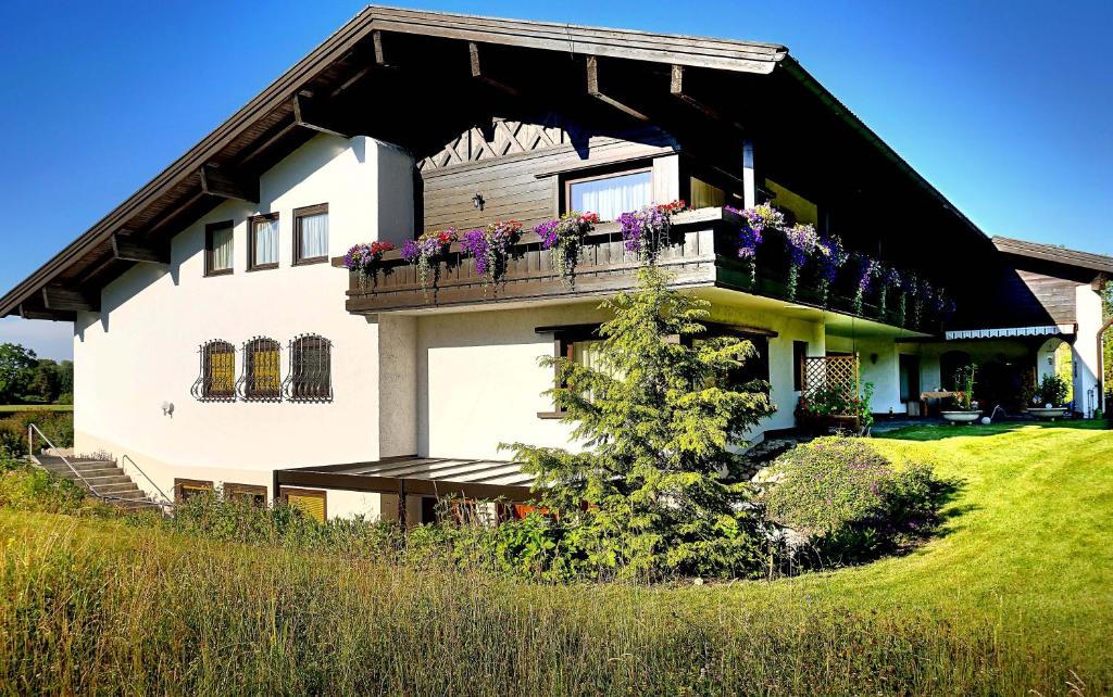 una casa con balcone fiorito di Ferienwohnungen Bachblick a Übersee