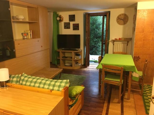 een woonkamer met een groene tafel en een televisie bij Appartamento Cretaz 2 in Valtournenche