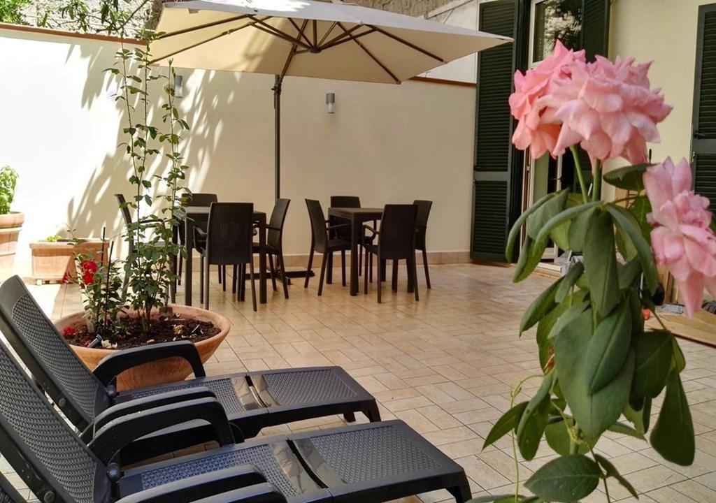 patio z krzesłami i stołem z różowymi kwiatami w obiekcie B&B al Centro Storico w mieście Napoli
