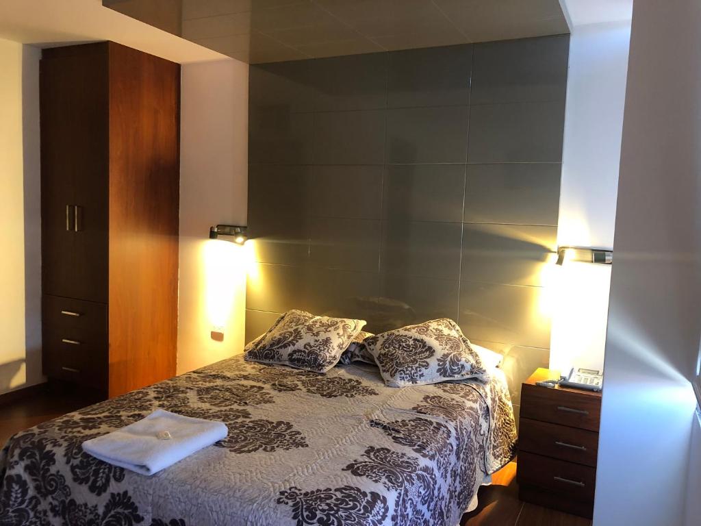 1 dormitorio con 1 cama con 2 almohadas en Hotel Bacastell, en Quito
