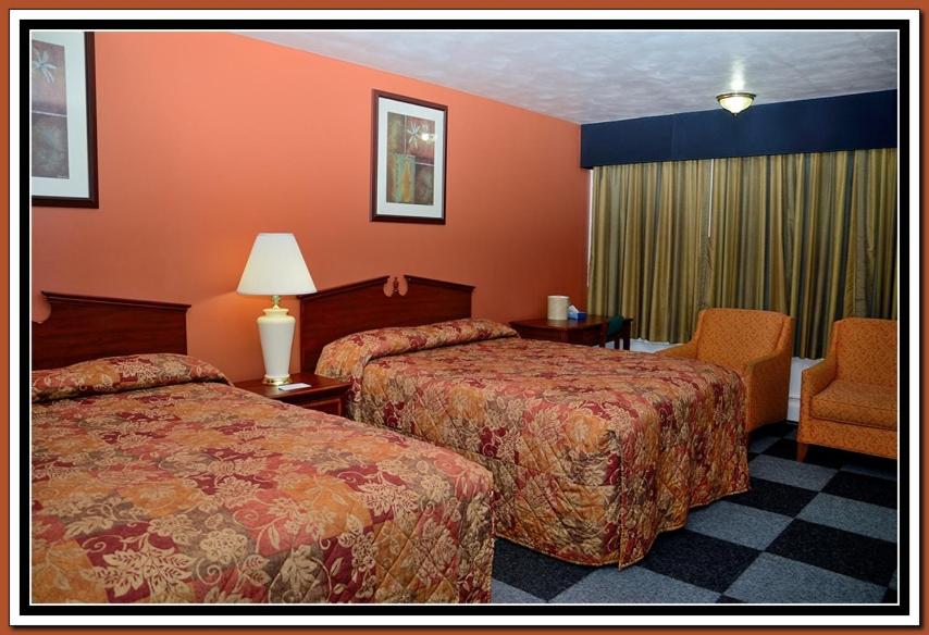 
a hotel room with two beds and two lamps at The Cardinal Inn in Luray
