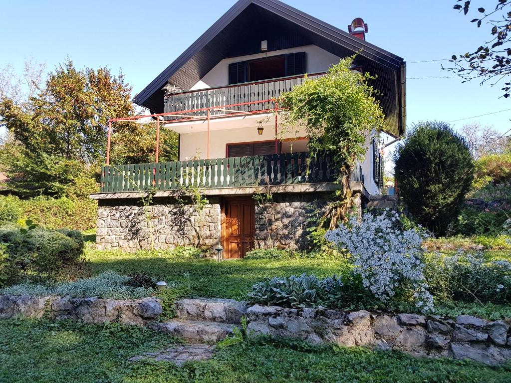 dom z drewnianymi drzwiami i balkonem w obiekcie Kuća za odmor "Livadica" w mieście Netretić