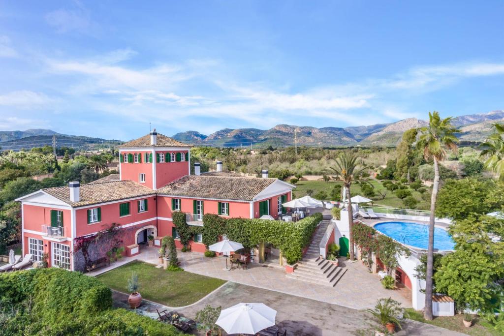 een luchtzicht op een roze huis met een zwembad bij Fincahotel Los Naranjos in Son Sardina