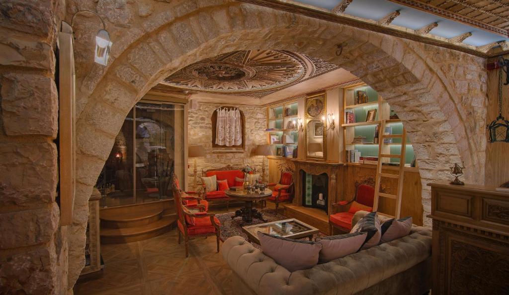 ein Wohnzimmer mit einer Steinmauer und einem Sofa in der Unterkunft KAMARES Historic Boutique Hotel & Spa in Ioannina
