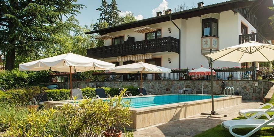 a house with a swimming pool and two umbrellas at Villa Eleonora in Merano
