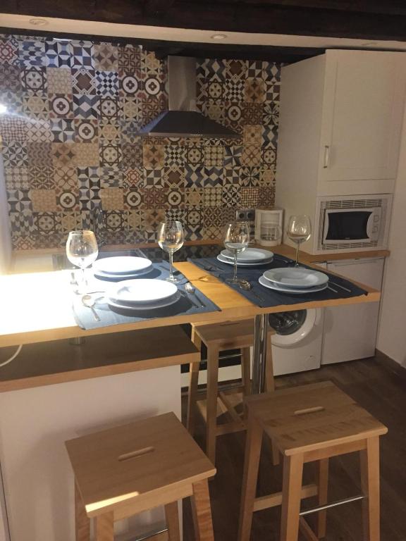 a kitchen with a table with glasses of wine at Apartamentos El Greco in Toledo