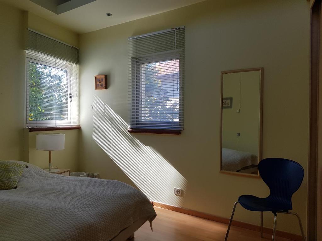 1 dormitorio con cama, espejo y silla en Bright, inviting, unique architecture, great location flat en Bet Shemesh