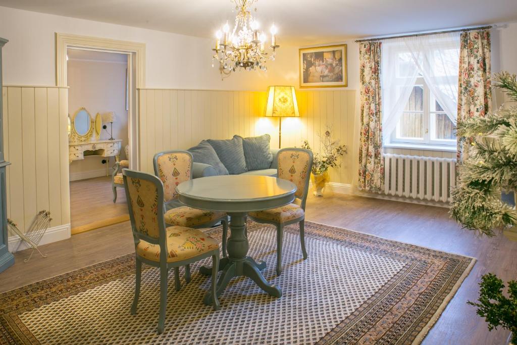 sala de estar con mesa, sillas y sofá en Romance Apartment en Kuldīga