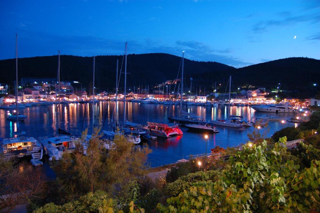 a marina at night with boats in the water at Nicolas Rooms in Fiskardho