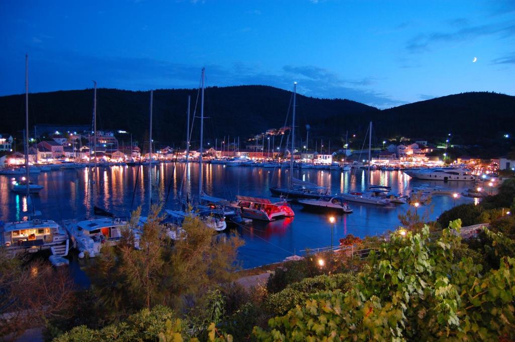 a marina at night with boats in the water at Nicolas Rooms in Fiskardo