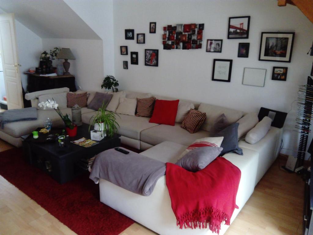 a living room with a white couch with pillows at Chez Mag in Lille