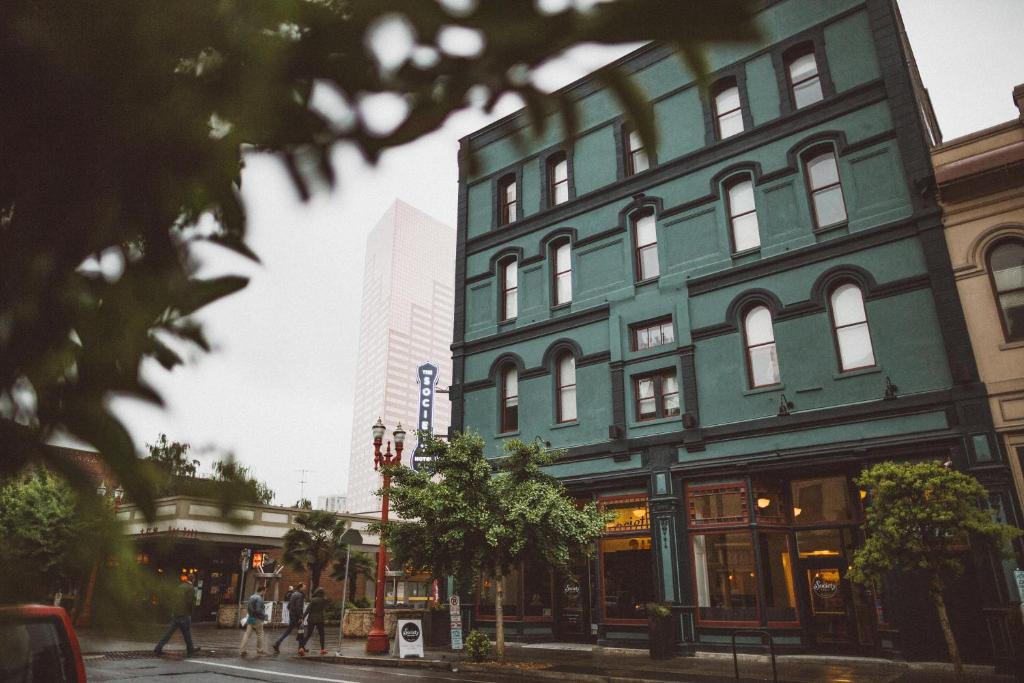 a green building on a street in a city at The Society Hotel in Portland