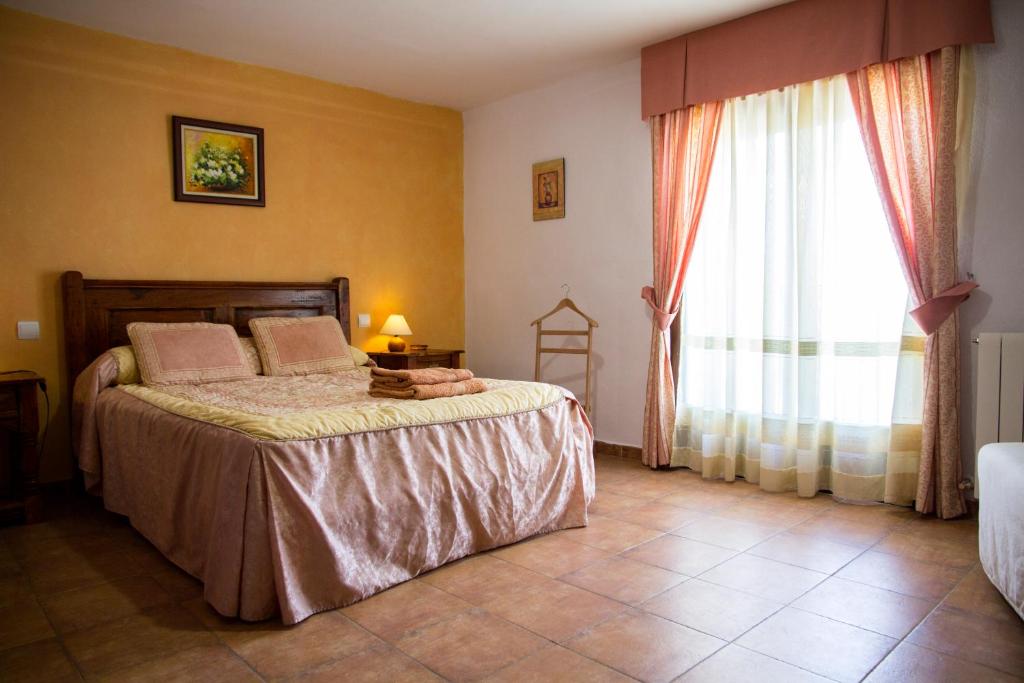 sypialnia z łóżkiem i dużym oknem w obiekcie Casa Rural Julian w mieście Medinaceli