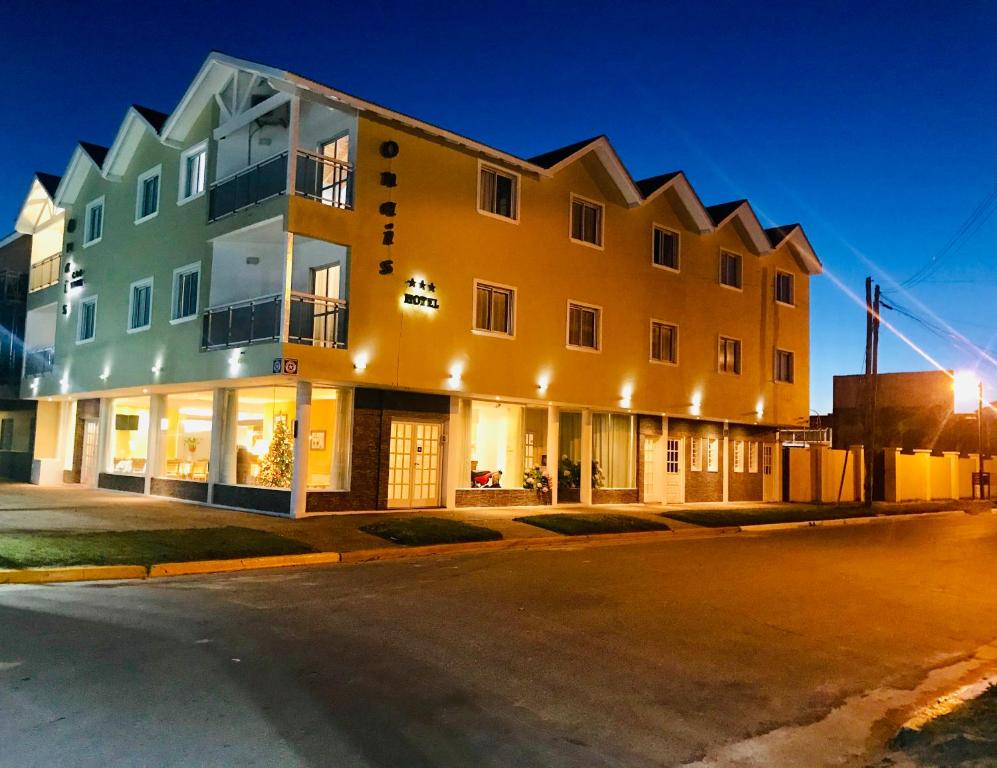 a building on the corner of a street at night at Onais Hotel in Mar de Ajó