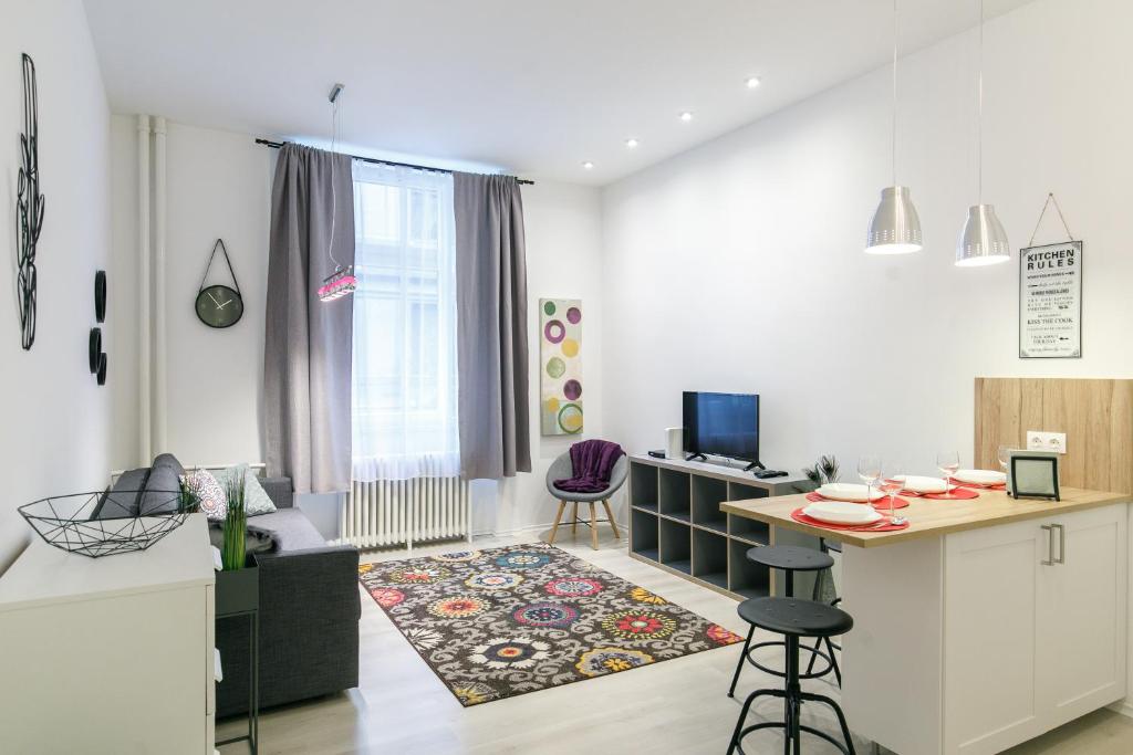 eine Küche und ein Wohnzimmer mit einem Tisch und Stühlen in der Unterkunft ELLA Apartment in Budapest