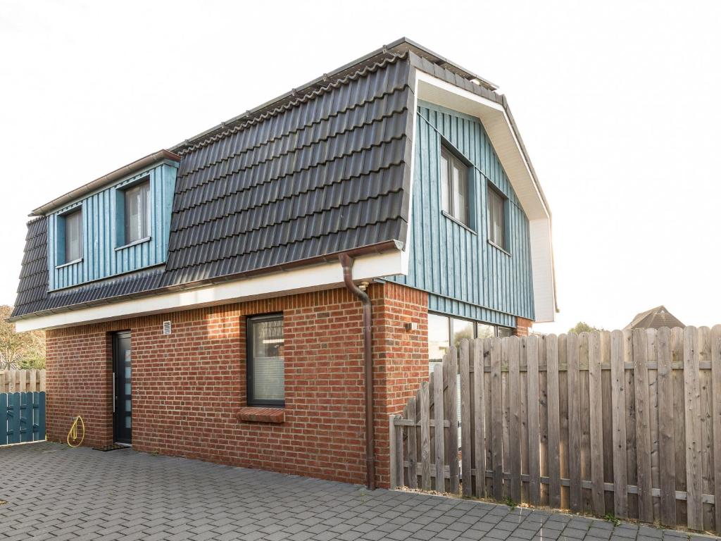 een rood bakstenen huis met een blauw dak bij Haus Emil in Cuxhaven