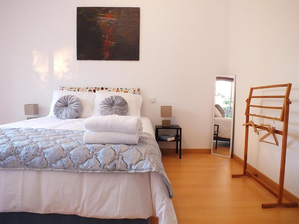 1 dormitorio con 1 cama y una pintura en la pared en Clarinha House, en Fátima