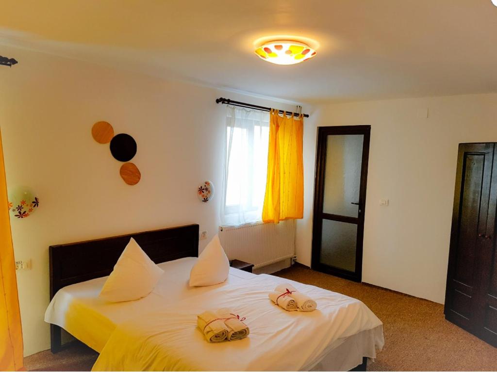 LupeniにあるCabana Alenaの2匹のカメが乗った白いベッドのある寝室