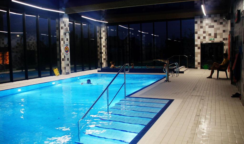 ein großer Swimmingpool mit Menschen darin in der Unterkunft APARTAMENT 5 MÓRZ SPA - NA FALI in Sianożęty