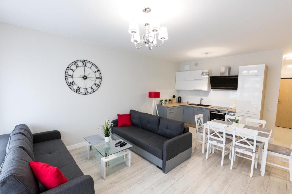 a living room with a couch and a table at Apartament 4k Nautica Szczecin in Szczecin