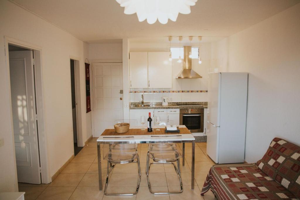 a kitchen with a table and chairs and a refrigerator at Home Nina in Playa de las Americas