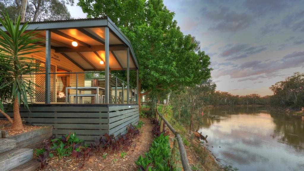 a house on the water with a river at Moama Riverside Holiday Park in Moama
