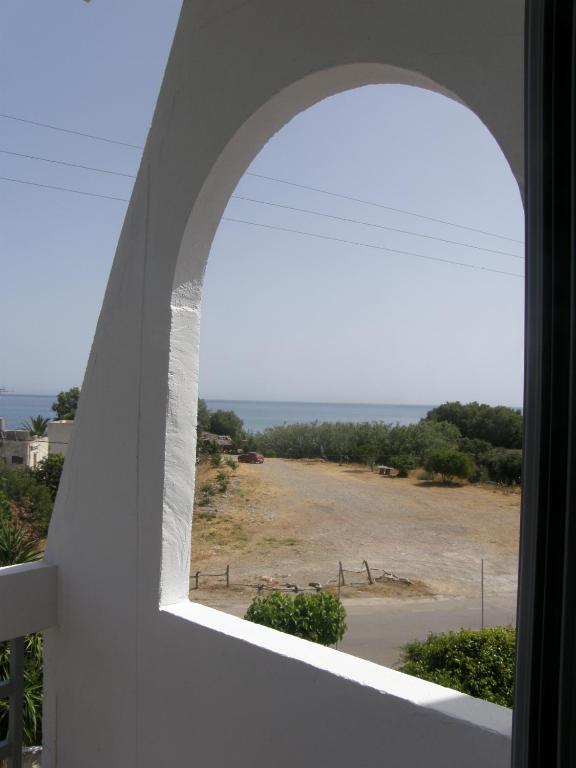 an arched window with a view of a field at Megim Hotel in Palaiochora