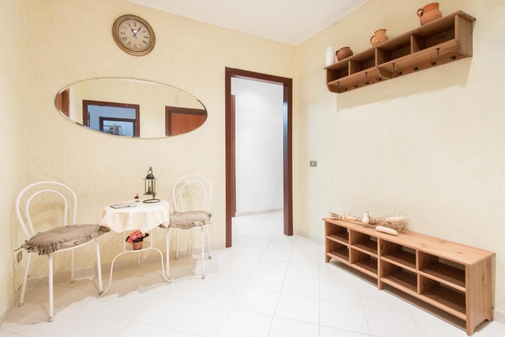 リド・ディ・オスティアにあるB&B Soggiorno Di Ostiaのテーブル、椅子、鏡が備わる客室です。