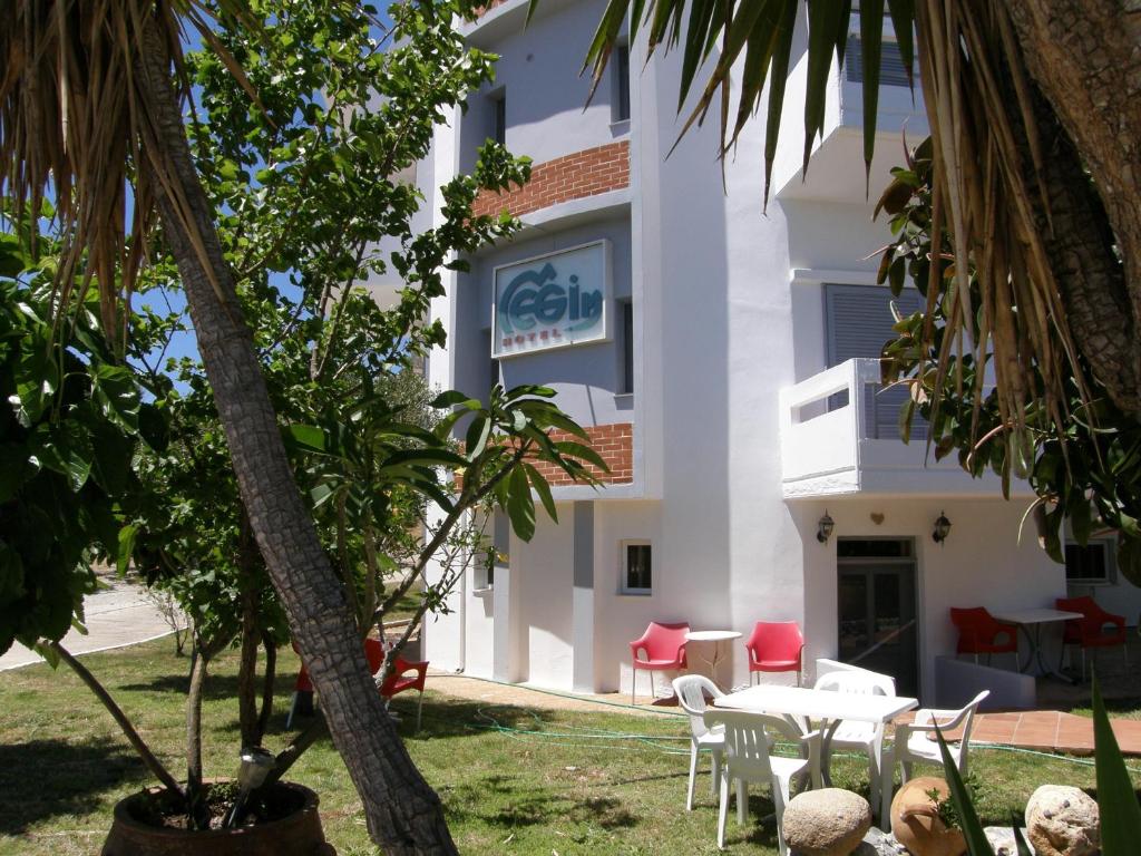 a building with a table and chairs in front of it at Megim Hotel in Palaiochóra