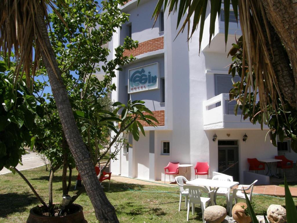 a building with a table and chairs in front of it at Megim Hotel in Palaiochora