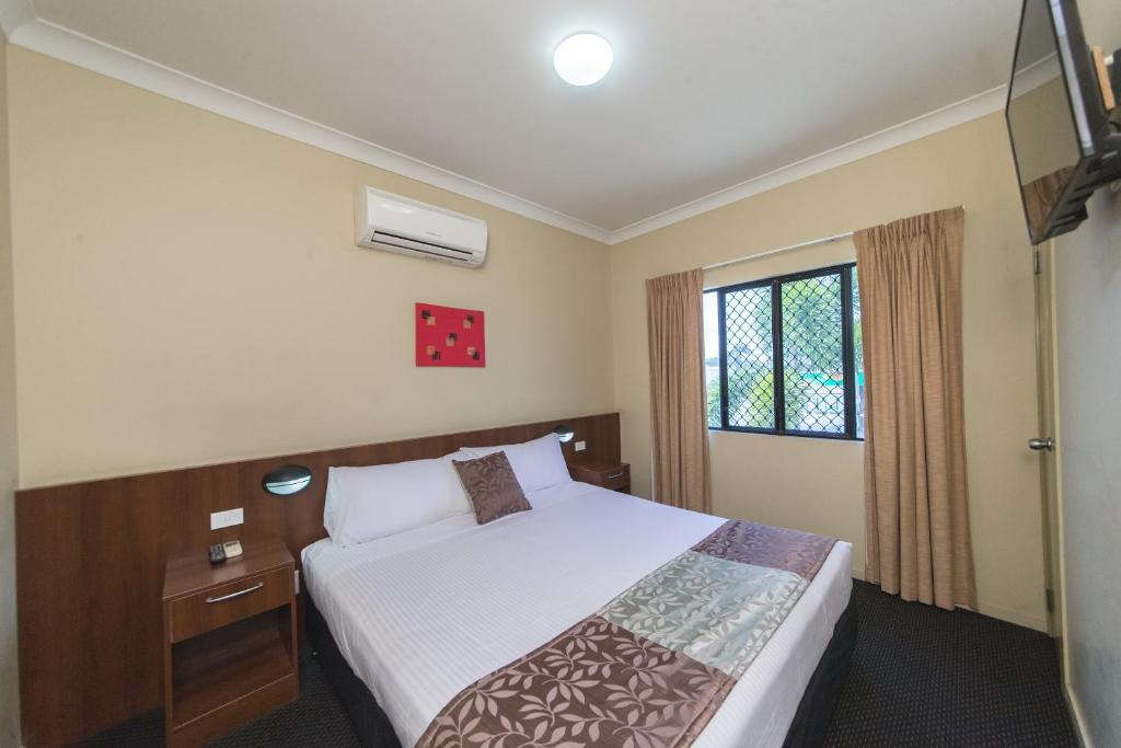 
a bedroom with a white bed and white walls at Rocky Resort Motor Inn in Rockhampton
