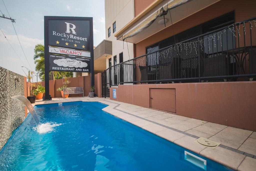 a swimming pool in front of a building at Rocky Resort Motor Inn in Rockhampton