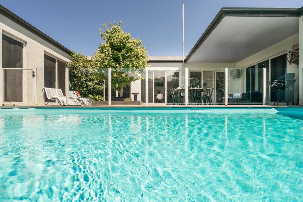 a swimming pool in front of a house at The Portsea Hideaway in Portsea