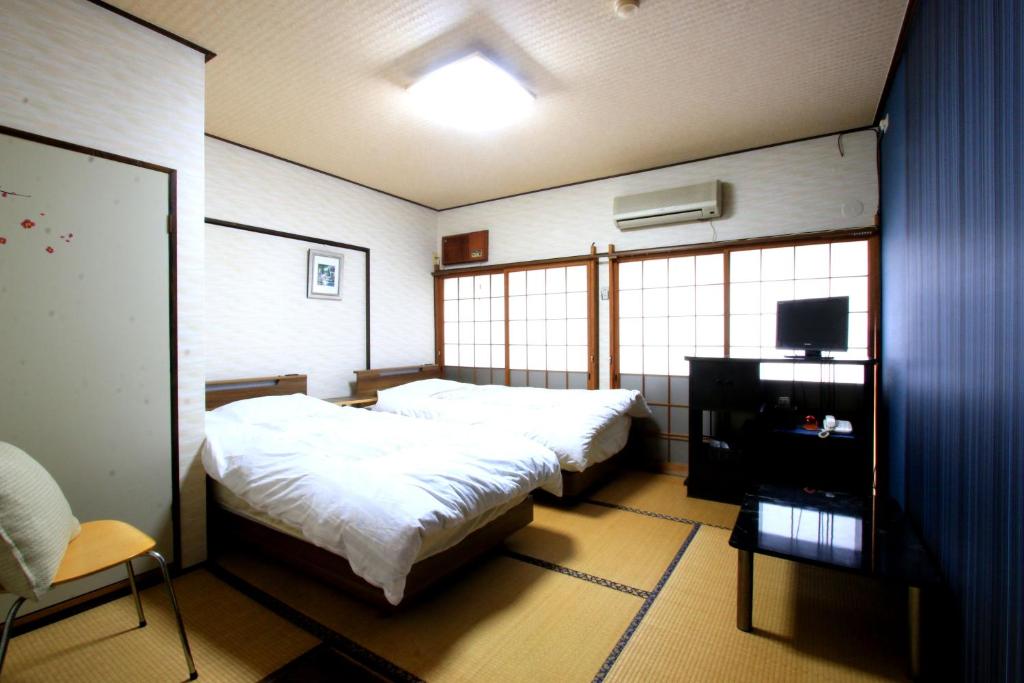 Postel nebo postele na pokoji v ubytování Ryokan Kibun