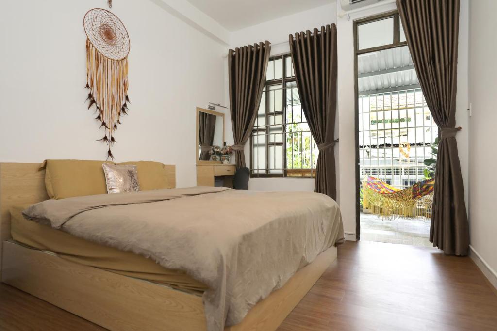 a bedroom with a bed and a large window at Saigon April Homestay in Ho Chi Minh City