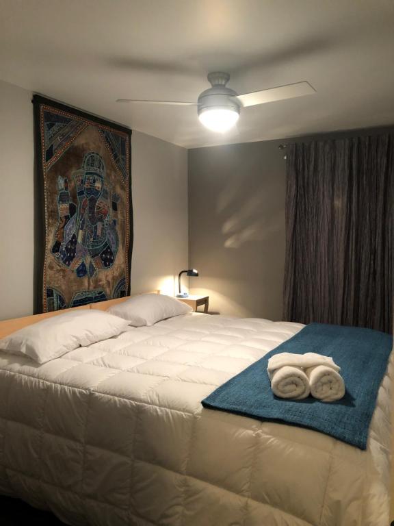 a bedroom with a bed with two towels on it at Gîte Zazen in Mont-Laurier